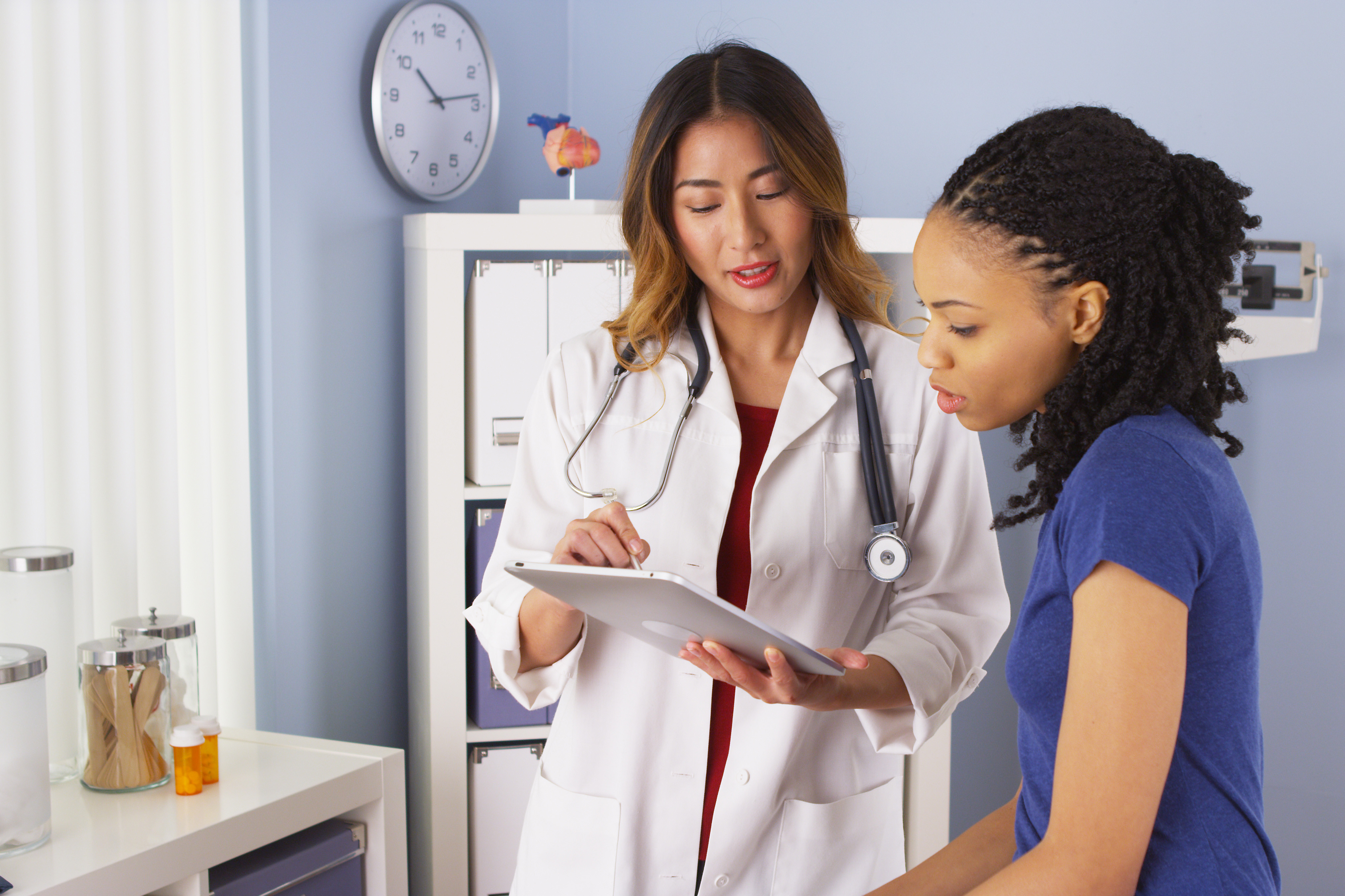 Female physician explaining something on a tablet to her patient